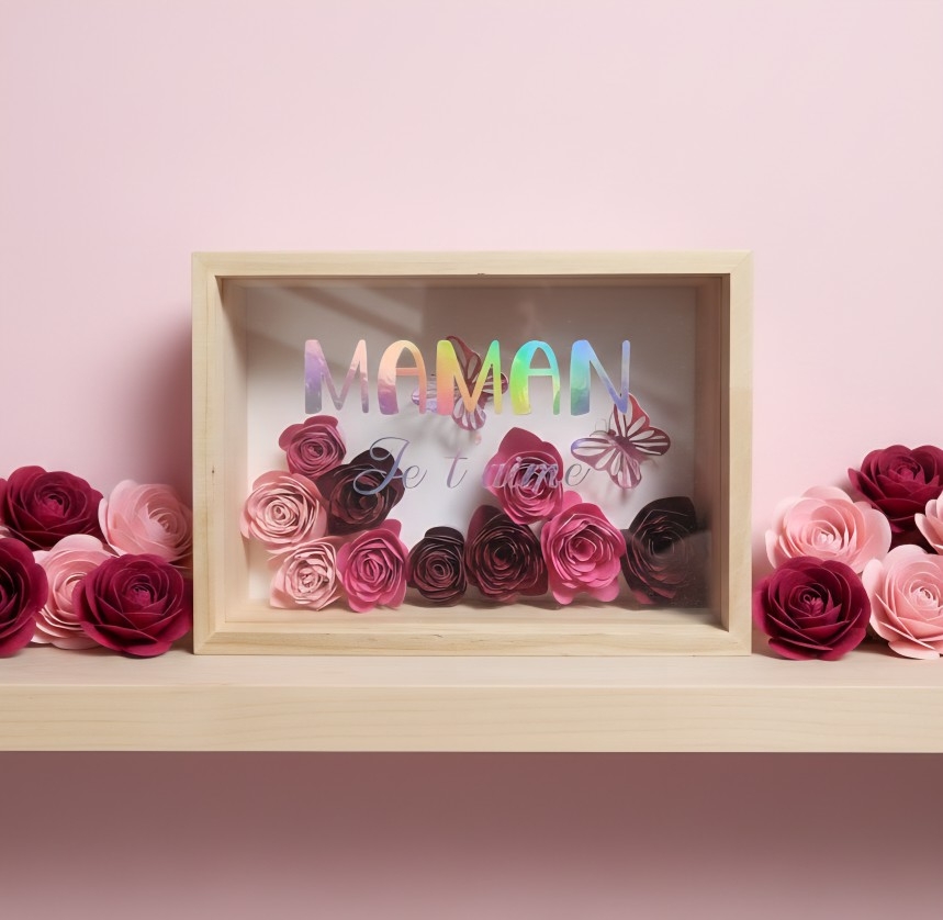 Cadre "Maman je t'aime", orné de fleurs rose clair, rose et fuchsia avec deux papillons holographiques roses.