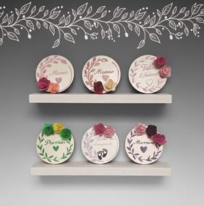 2 étagères en bois présentant six magnets rond avec fleurs de différentes couleurs.